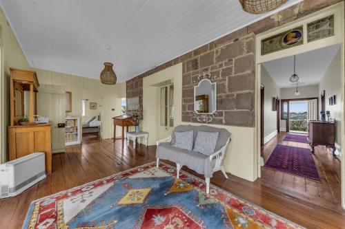 a living room with a chair and a stone wall at Munns Tower House in Merimbula