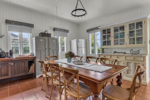 a kitchen with a table and chairs and a refrigerator at Munns Tower House in Merimbula