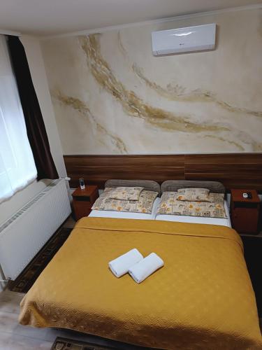 a bedroom with a bed with two white towels on it at Boglárka Vendégház in Mosonmagyaróvár