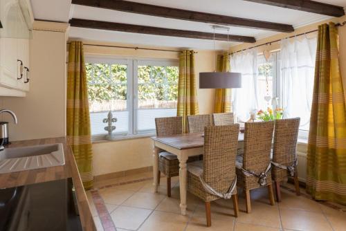 une cuisine avec une table et des chaises en bois ainsi qu'une fenêtre dans l'établissement Altes Strandhus Casa Stranddune, à Scharbeutz