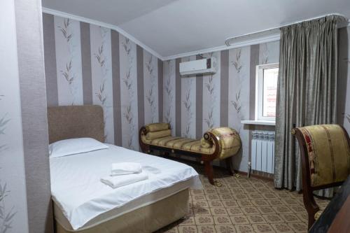 una piccola camera con letto e sedia di Алматы Транзит №1 a Turksib