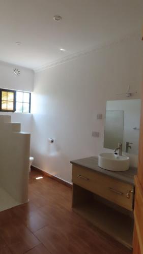 Samburu Dik-Dik House & Susuk Self-catering Cottage في Archers Post: حمام مع حوض ومرآة