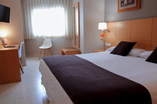 アリカンテにあるLa City Estaciónの大きなベッドと窓が備わるホテルルームです。