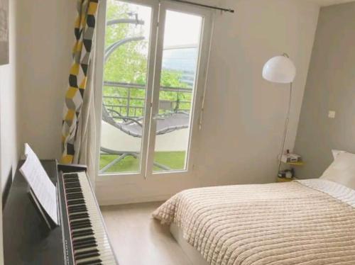 Schlafzimmer mit einem Bett, einem Fenster und einer Tastatur in der Unterkunft Cosy home near Paris Olympics 2024, Rueil Malmaison in Rueil-Malmaison