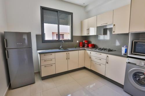 a kitchen with a stainless steel refrigerator and a window at Hanah Apartments by Living Essaouira in Essaouira