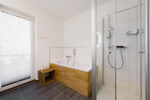 a bathroom with a bath tub and a shower at SchleiZeit in Olpenitz