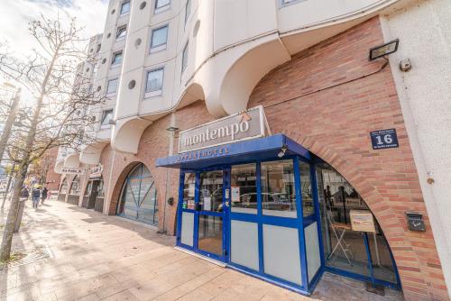 un bâtiment avec une porte bleue dans une rue dans l'établissement Montempô Apparthôtel Evry, Évry-Courcouronnes