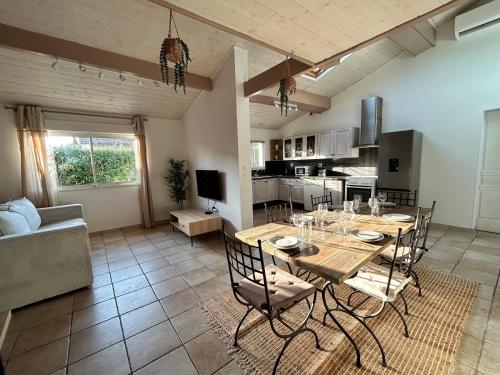 une salle à manger et une cuisine avec une table et des chaises dans l'établissement Maison 4pers terrasse wifi parking, à Talence
