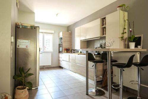 - une cuisine avec un comptoir et quelques tabourets dans l'établissement Maison spacieuse, quartier La Madeleine, terrasse et jardin, à La Madeleine