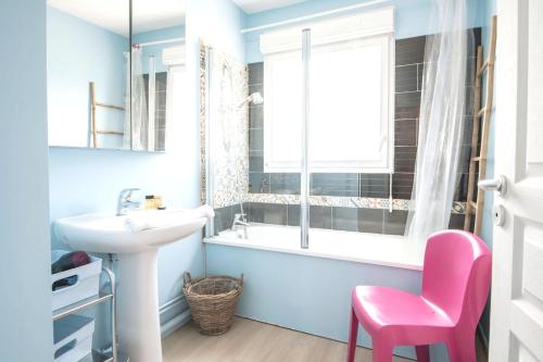 a bathroom with a sink and a pink chair at Maison spacieuse, quartier La Madeleine, terrasse et jardin in La Madeleine