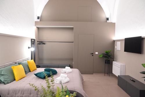 a bedroom with a large bed with colorful pillows at Dimora Minelli Suites in Monopoli