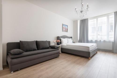 a living room with a couch and a bed at Prague Serenity Suites and Apartments in Prague