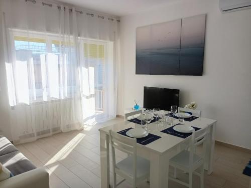 uma sala de estar com uma mesa branca com copos de vinho em DanysHome Circe vista mare em Terracina