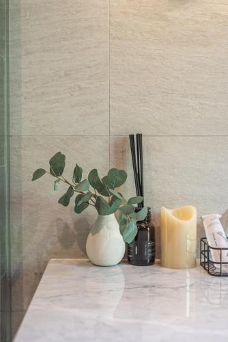 a white vase with a plant on a counter at The Lai Tiny House - Villa at Mae Kampong in Chiang Mai
