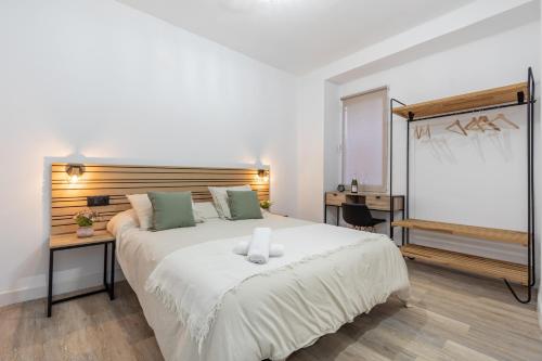 1 dormitorio con 1 cama blanca grande y escritorio en Suite patio del arquitecto, en Granada