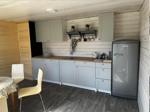 a kitchen with white cabinets and a refrigerator at Hede suvemajad/summer houses in Pärnu