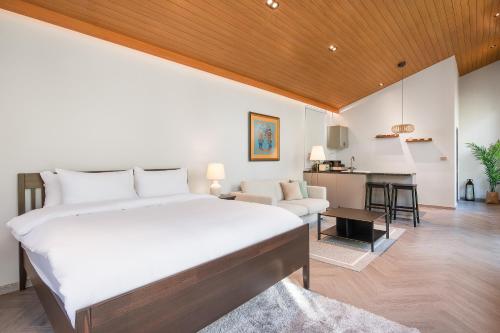 a bedroom with a bed and a living room at The Lai Tiny House - Villa at Mae Kampong in Chiang Mai