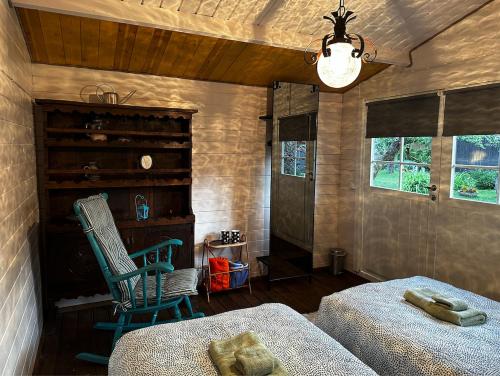 1 dormitorio con 2 camas, silla y lámpara de araña en Hede suvemajad/summer houses, en Pärnu