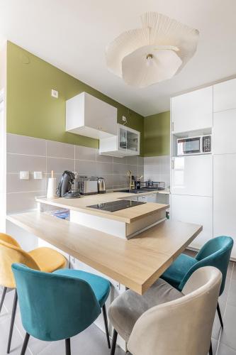 une cuisine avec un comptoir en bois et des chaises bleues dans l'établissement Cocon Mad'Mazelle - Hyper centre - 4P, à Metz