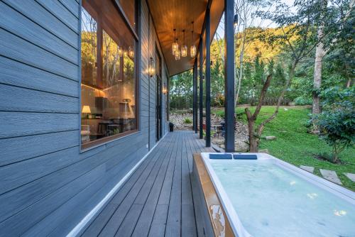 a house with a swimming pool on a wooden deck at The Lai Tiny House - Villa at Mae Kampong in Chiang Mai