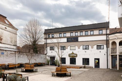 a large white building with benches in front of it at RIVA sleep & chill in Valjevo