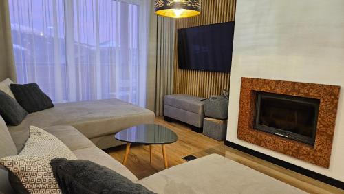 a living room with a couch and a fireplace at Apartmán Zina Donovaly in Donovaly
