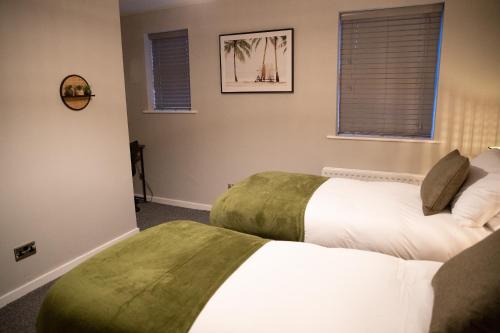 a bedroom with two beds and two windows at 2 Bedroom Property with Free Parking close to Leeds City Centre in Leeds