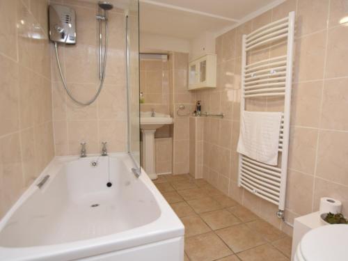 a bathroom with a tub and a sink at 2 Bed in West Bay 77557 in Loders