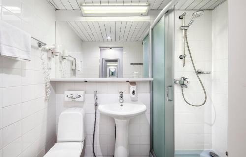 a white bathroom with a sink and a shower at Hestia Hotel Susi in Tallinn