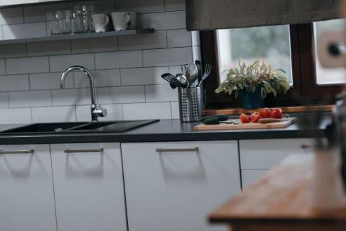 a kitchen counter with a sink and vegetables on a cutting board at Cozy country home with heated outdoor pool in Šibenik