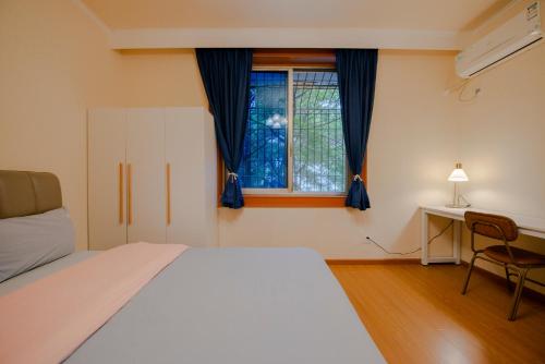 a bedroom with a bed and a window at Arthur's Roof-Top in Chengdu