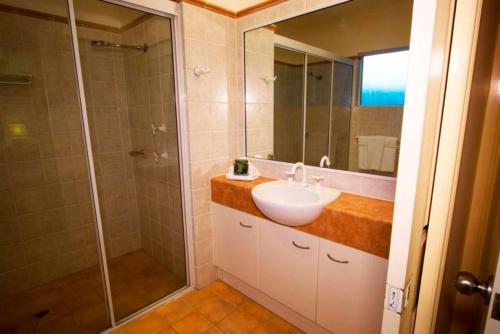 棕榈湾Ivy at Coral Horizons: A Retro Beachfront Locale的带水槽和淋浴的浴室