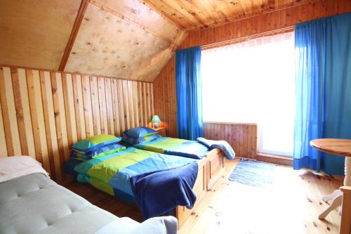 a bedroom with two beds and a large window at Dom Letniskowy Nela Rowy in Rowy