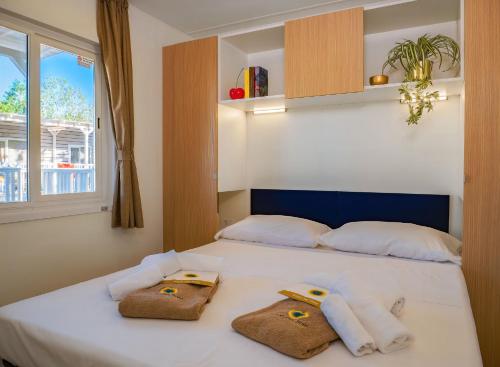 a bedroom with a white bed with towels on it at Club del Sole Tenuta Primero Grado Family Collection in Grado