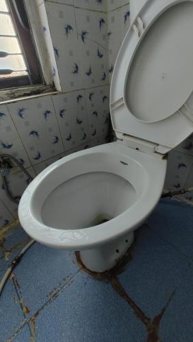 uma casa de banho com um WC branco num quarto em Hotel Mansarovar em Dailekh