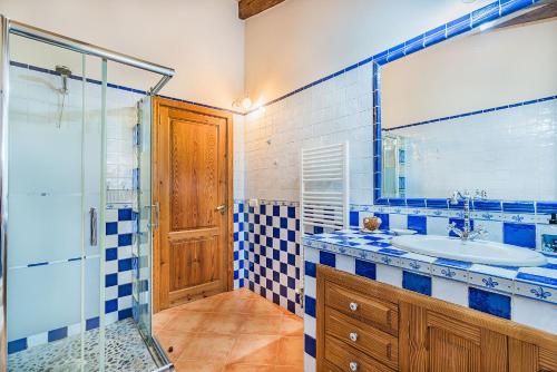 ein blau-weißes Bad mit einem Waschbecken und einer Dusche in der Unterkunft Finca Los Valles in Campanet