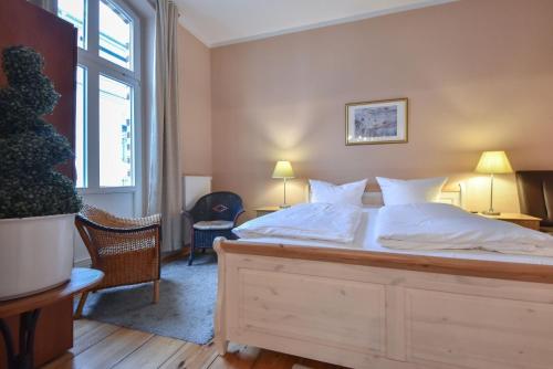 sypialnia z dużym łóżkiem z białą pościelą w obiekcie Villa Magdalena 02 w mieście Ahlbeck