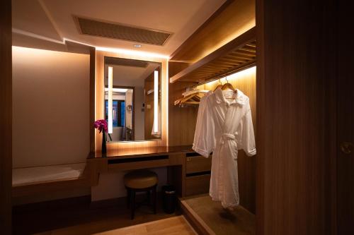 a robe hanging in a bathroom with a mirror at The Garden Hotel Guangzhou - Discover 26 cultural treasures with hotel Golden Tour Guide in Guangzhou