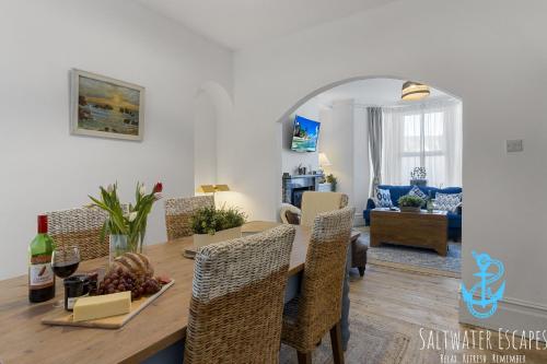 a dining room and living room with a table and chairs at Little Fish in Brixham