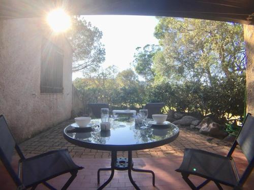 - une table et des chaises sur la terrasse dans l'établissement Villa Occhiatana, Santa Giulia, à Porto-Vecchio