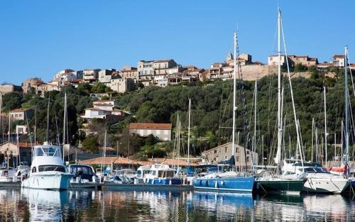 a group of boats docked in a harbor with houses at Villa Occhiatana, Santa Giulia in Porto-Vecchio