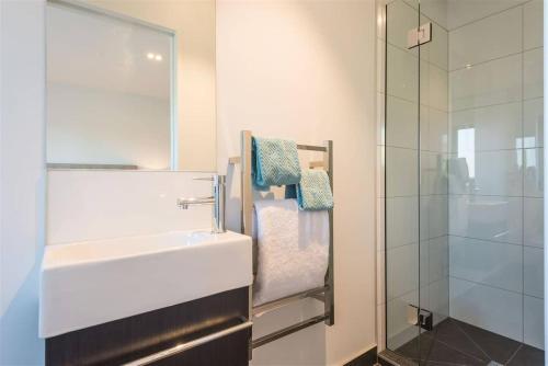 a bathroom with a sink and a glass shower at Hagley park Hidden Gem in Christchurch