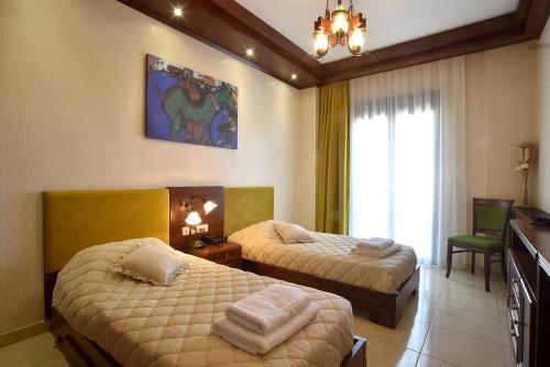 een slaapkamer met 2 bedden en een raam bij Alexander Mountain Resort in Yerakárion