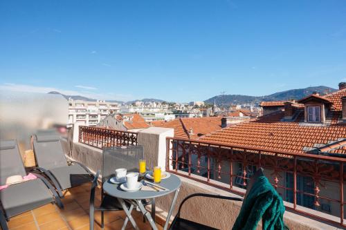 a balcony with a table and a view of a city at Best Western Plus Hôtel Massena Nice in Nice