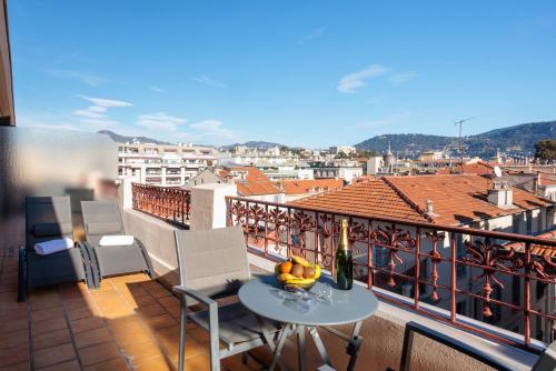 a balcony with a table with fruit and a bottle of wine at Best Western Plus Hôtel Massena Nice in Nice