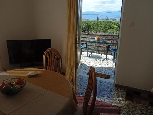 a room with a table and a view of a patio at Serene Country House (near Ancient Tiryns) in Nafplio