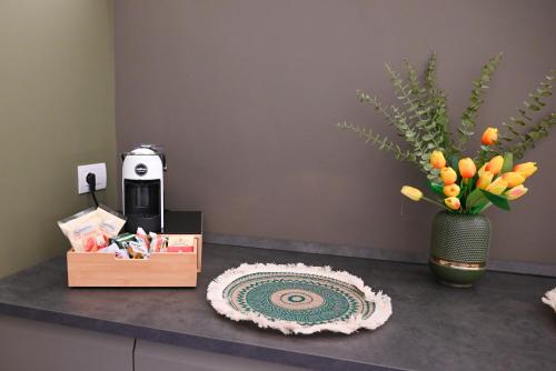 a counter with a vase of oranges and a box of flowers at Dimora Minelli Suites in Monopoli