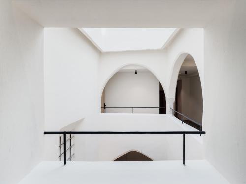 une étagère en verre dans une chambre blanche avec une arche dans l'établissement ADLER Historic Guesthouse, à Bressanone