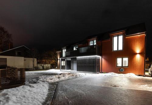 a house on a snowy street at night at Posti villa in Pärnu
