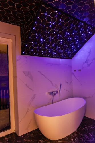 a bath tub in a bathroom with purple lighting at Posti villa in Pärnu